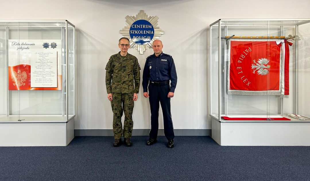 Generał broni prof. dr hab. Grzegorz Gielerak i insp. Ryszard Jakubowski Komendant Centrum Szkolenia Policji w Legionowie pozują do zdjęcia. Za nimi napis Centrum Szkolenia Policji.