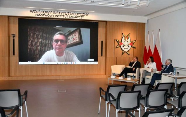 Znaczenie zasady profesjonalizmu lekarskiego - panel dyskusyjny. Na ścianie na ekranie jeden z uczestników konferencji.