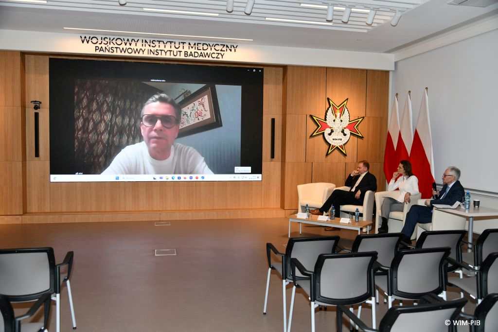 Znaczenie zasady profesjonalizmu lekarskiego - panel dyskusyjny. Na ścianie na ekranie jeden z uczestników konferencji.