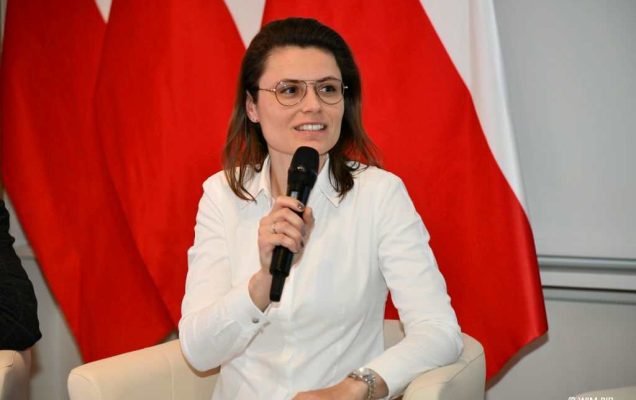 Dr hab. n.  prawnych Aneta Łazarska siedzi z mikrofonem w dłoni podczas panelu dyskusyjnego.