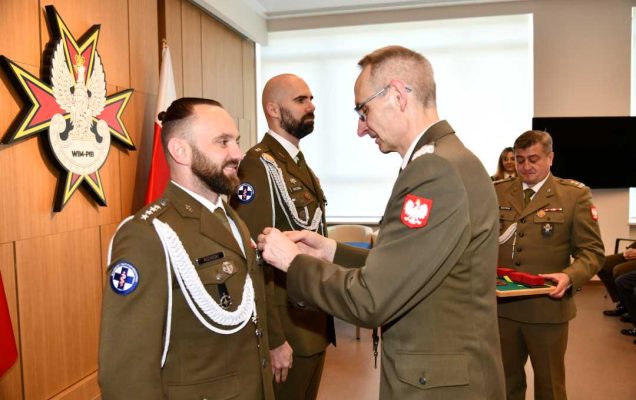 Dyrektor Wojskowego Instytutu Medycznego - Państwowego Instytutu Medycznego gen. broni prof. dr hab. n. med. Grzegorz Gielerak przypina Gwiazdę Iraku Damianowi Różańskiemu.