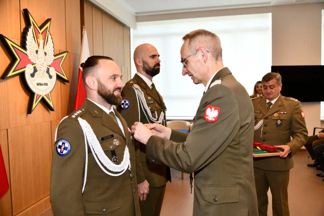 Dyrektor Wojskowego Instytutu Medycznego - Państwowego Instytutu Medycznego gen. broni prof. dr hab. n. med. Grzegorz Gielerak przypina Gwiazdę Iraku Damianowi Różańskiemu.