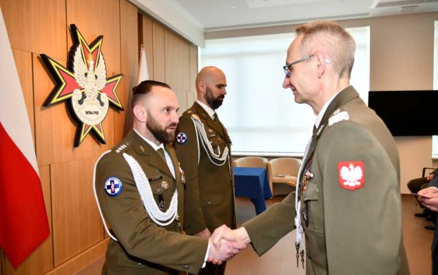 Dyrektor Wojskowego Instytutu Medycznego - Państwowego Instytutu Medycznego gen. broni prof. dr hab. n. med. Grzegorz Gielerak przypina Gwiazdę Iraku Damianowi Różańskiemu.