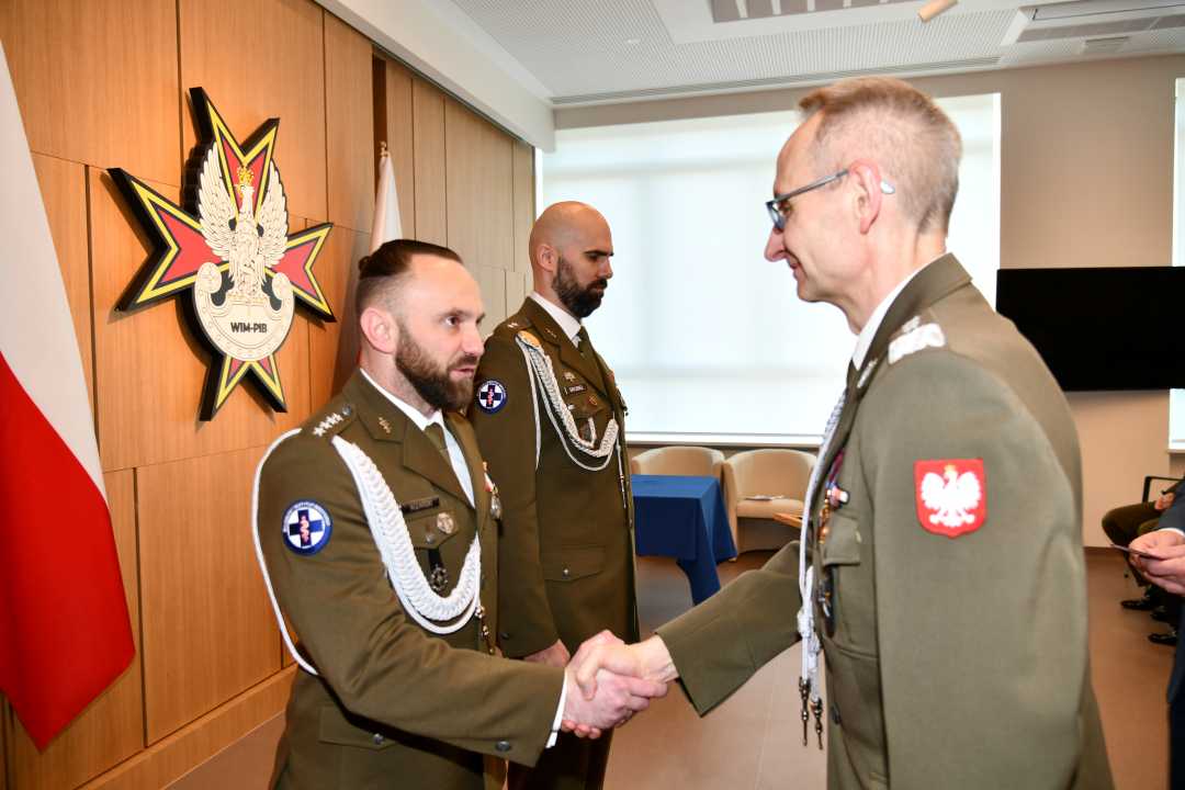 Dyrektor Wojskowego Instytutu Medycznego - Państwowego Instytutu Medycznego gen. broni prof. dr hab. n. med. Grzegorz Gielerak przypina Gwiazdę Iraku Damianowi Różańskiemu.