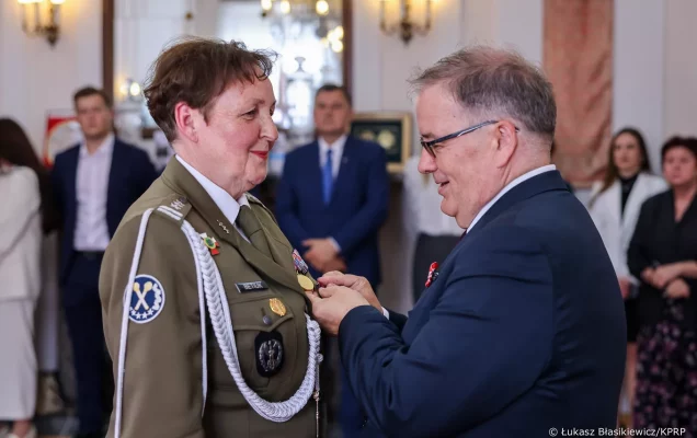 Minister Andrzej Dera przypina medal dr Barbarze Betiuk.