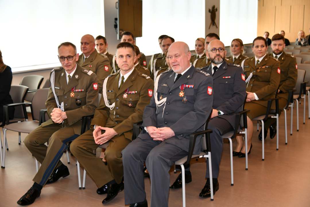 Siedzący goście na auli podczas uroczystości rozdania odznaczeń.