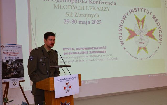 Młody lekarz w mundurze wojskowym przy mównicy.