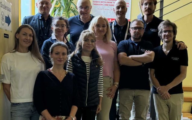 Zdjęcie grupowe na schodach wewnątrz budynku uczestników szkolenia Spasticity Management Masterclass.