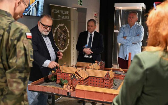 Pracownicy WIM w sali Muzeum Żołnierzy Wyklętych oglądają makietę budynku.
