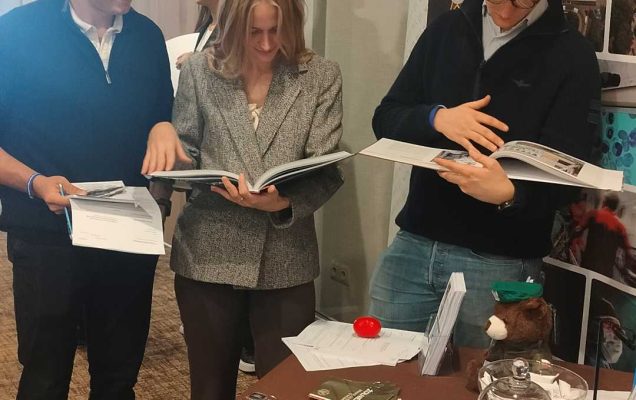 Studentki i studenci przeglądający materiały informacyjne przy stoisku WIM.