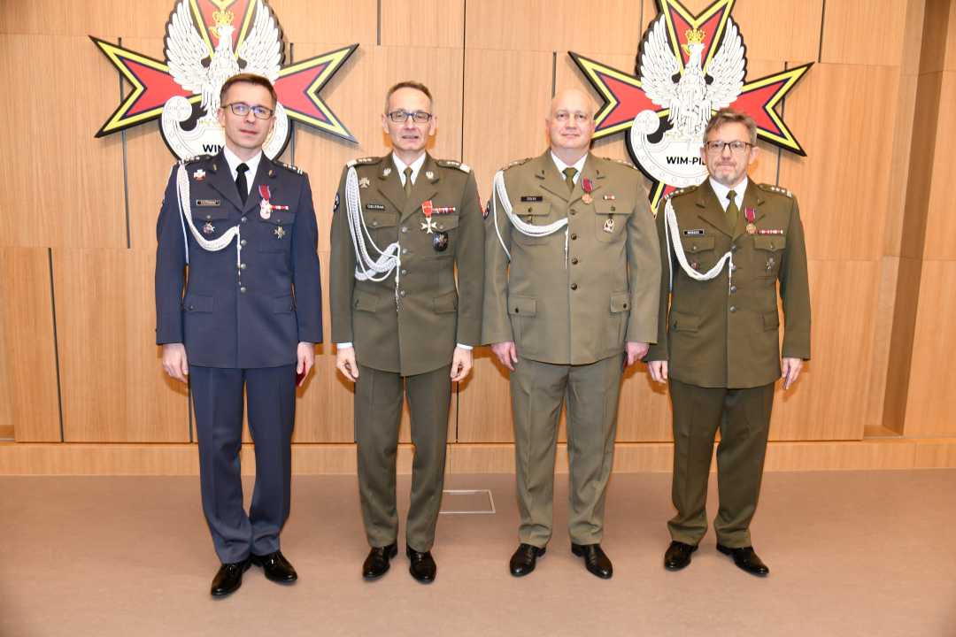 Dyrektor WIM pozuje do zdjęcia z pracownikami.