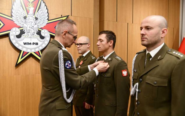 Dyrektor WIM wręcza odznaczenie.