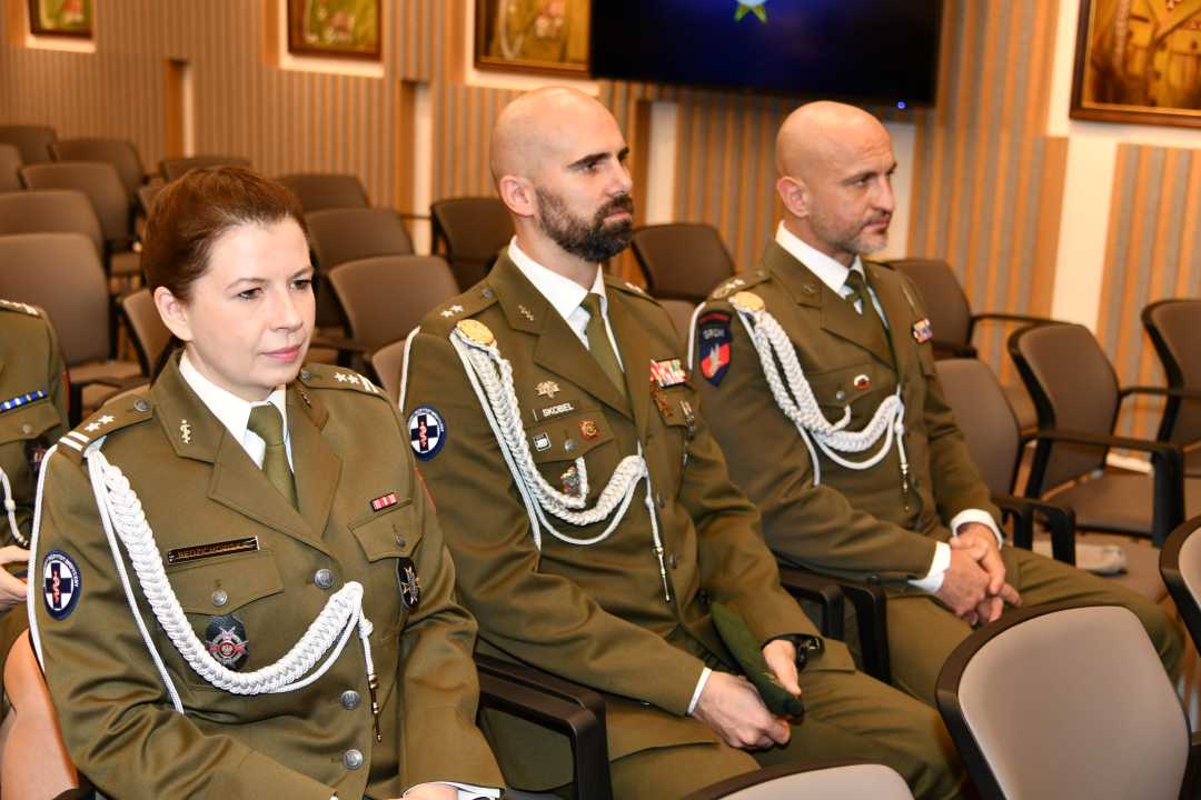 Uczestnicy siedzący na auli ubrani w wojskowe mundury.