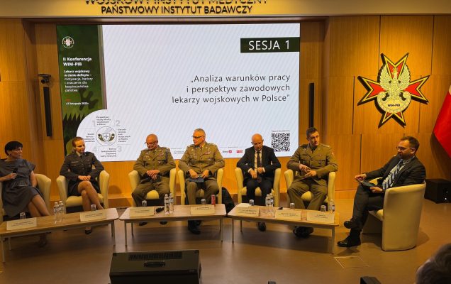 Uczestnicy siedzący w fotelach podczas panelu dyskusyjnego, za ich plecami wyświetlony fragment prezentacji.