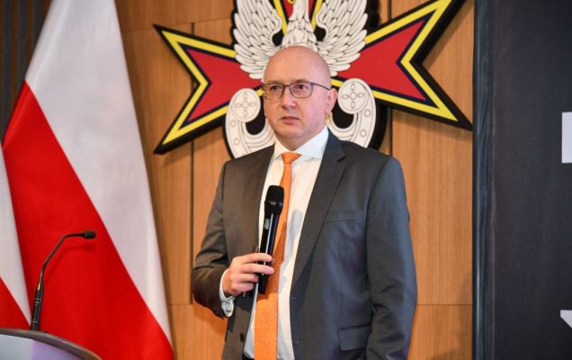 Prelegent z mikrofonem w dłoni podczas wykładu.