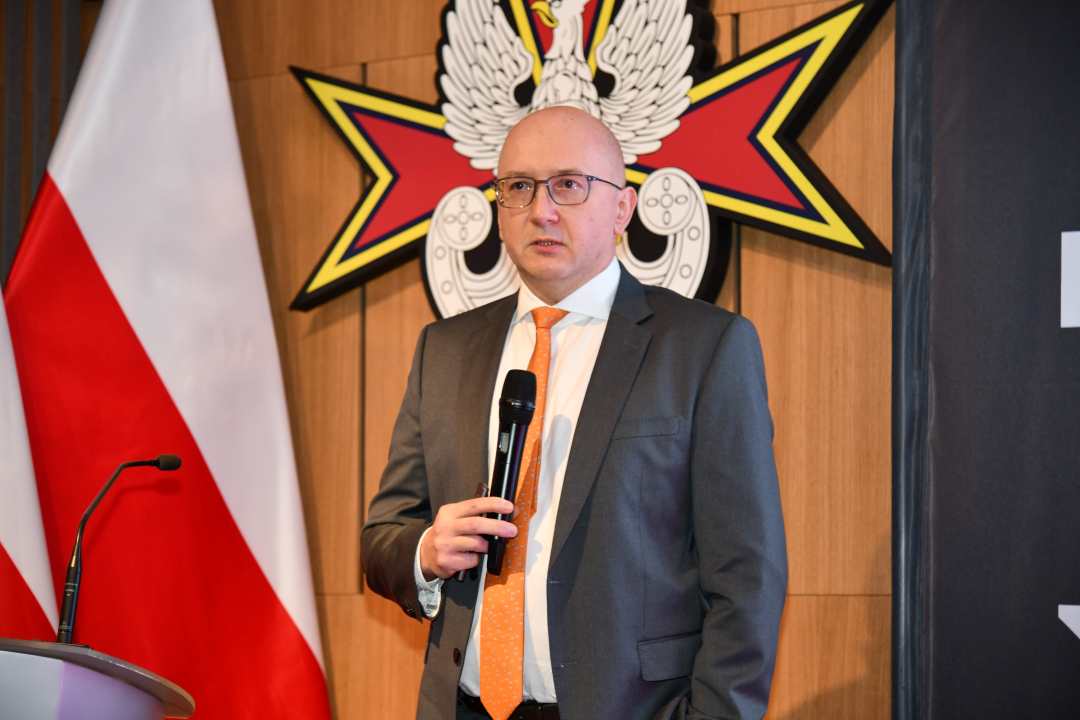 Prelegent z mikrofonem w dłoni podczas wykładu.