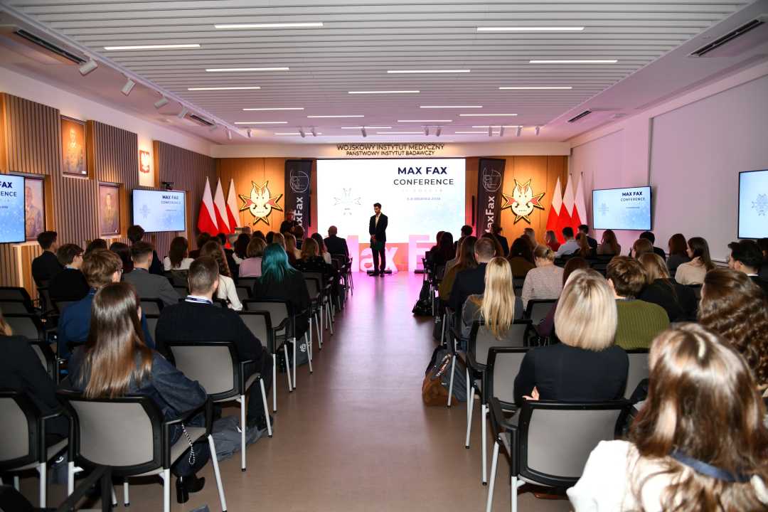 Ujecie auli z siedzącymi słuchaczami konferencji podczas wykładu.