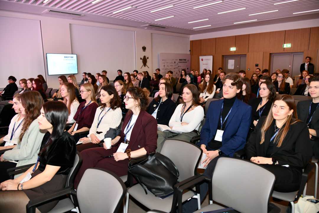 Siedzący słuchacze podczas konferencji.