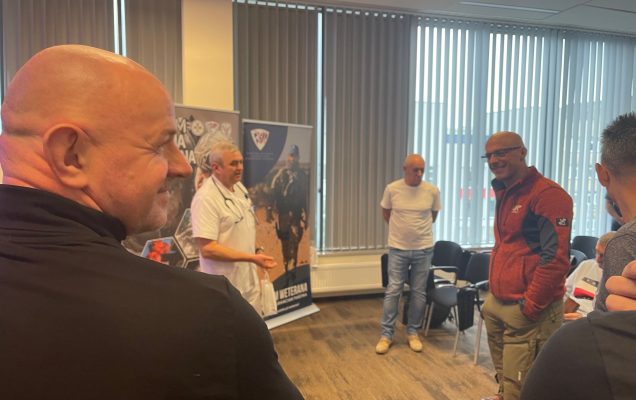 Słuchacze stoją na sali i rozmawiają z pracownikami WIM.