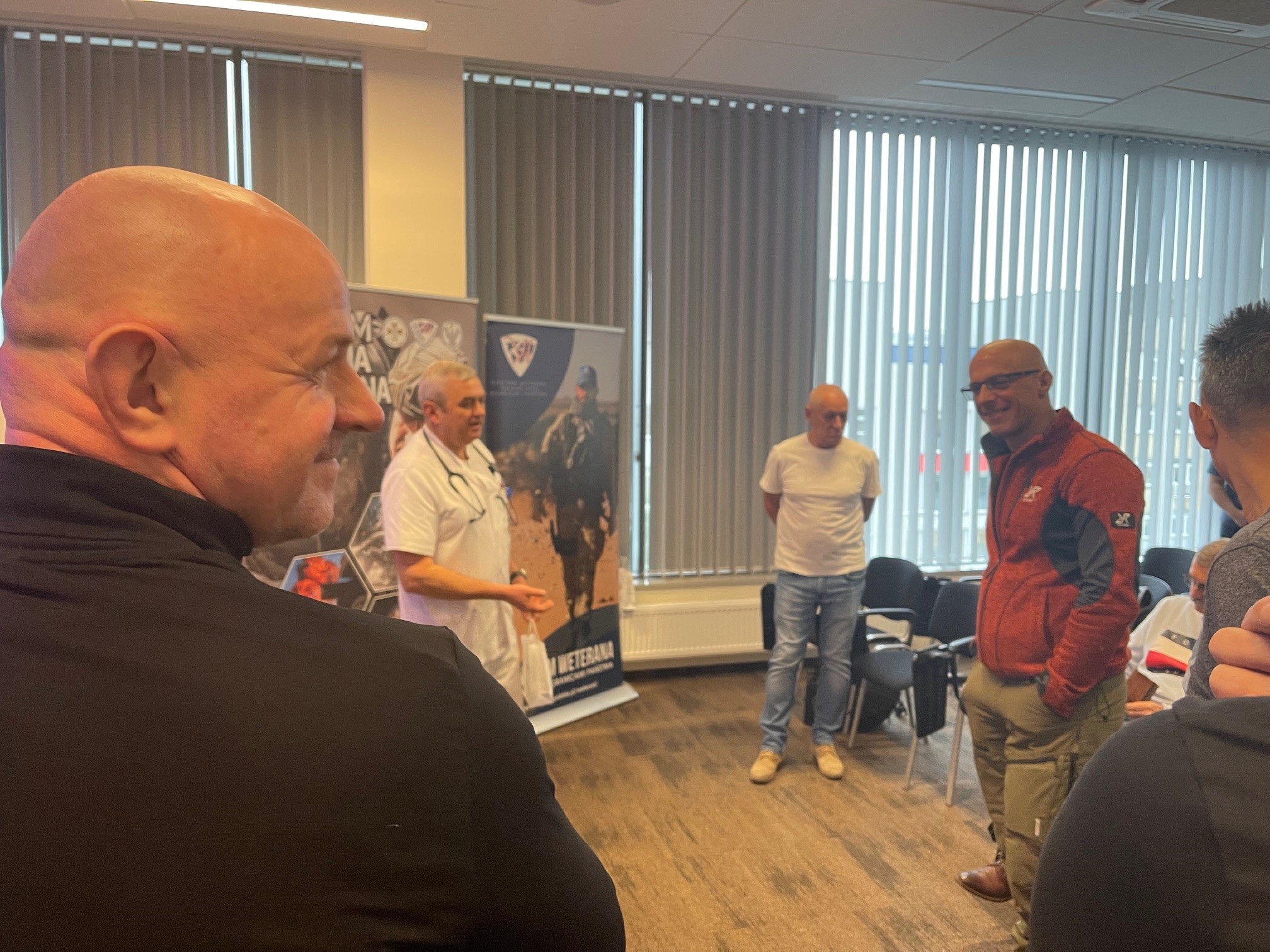 Słuchacze stoją na sali i rozmawiają z pracownikami WIM.