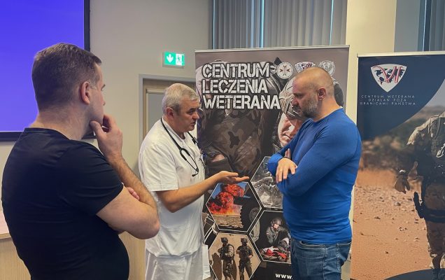 Słuchacze stoją na sali i rozmawiają z pracownikami WIM.