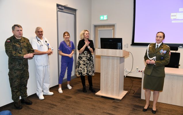 Pracownicy WIM stoją przy mównicy dziękując za uczestnictwo.