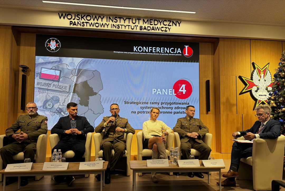 Dyrektor WIM Grzegorz Gielerak siedzi obok panelistów. Za nimi na ekranie plansza tytułowa panelu.