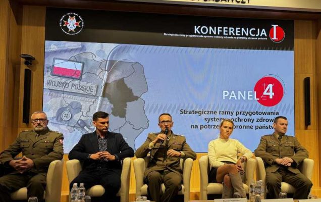 Dyrektor WIM Grzegorz Gielerak siedzi obok panelistów. Za nimi na ekranie plansza tytułowa panelu.