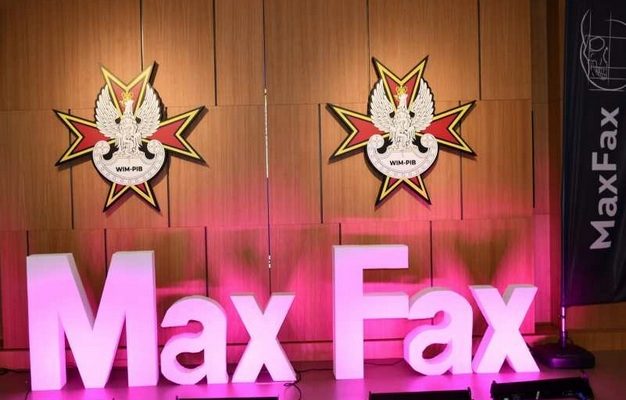 Podświetlony napis Max Fax na auli WIM. Za napisem na ścianę 2 logotypy WIM-PIB.