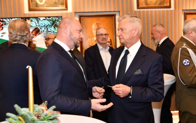 Goście i pracownicy dzielą się opłatkiem.