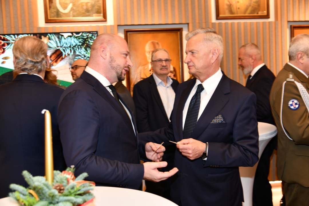 Goście i pracownicy dzielą się opłatkiem.