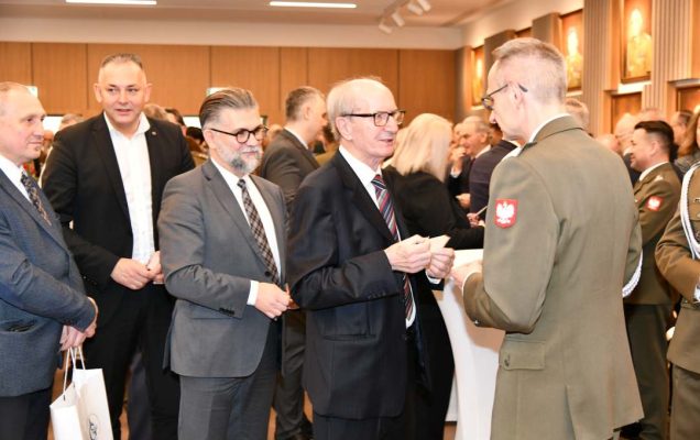 Dyrektor WIM dzieli się opłatkiem z pracownikami i gośćmi.