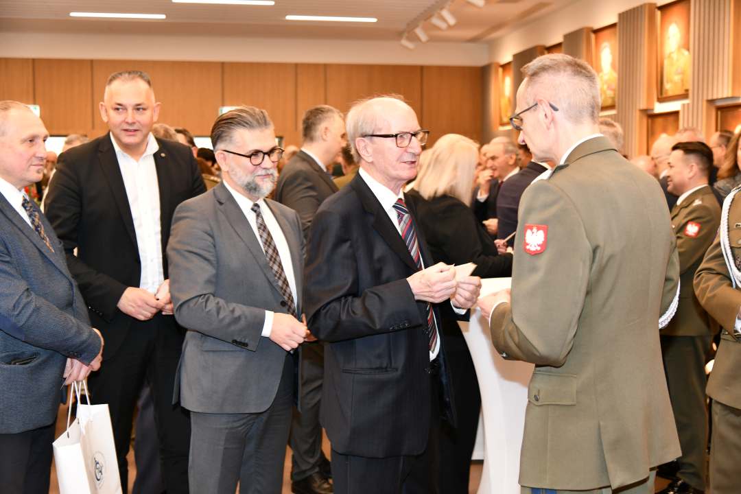 Dyrektor WIM dzieli się opłatkiem z pracownikami i gośćmi.