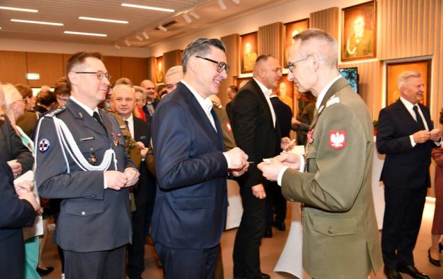 Dyrektor WIM dzieli się opłatkiem z pracownikami i gośćmi.