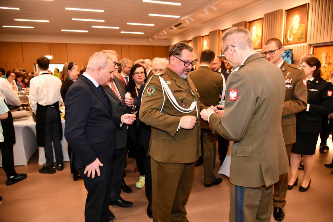 Dyrektor Wim dzieli się opłatkiem z pracownikami WIM.