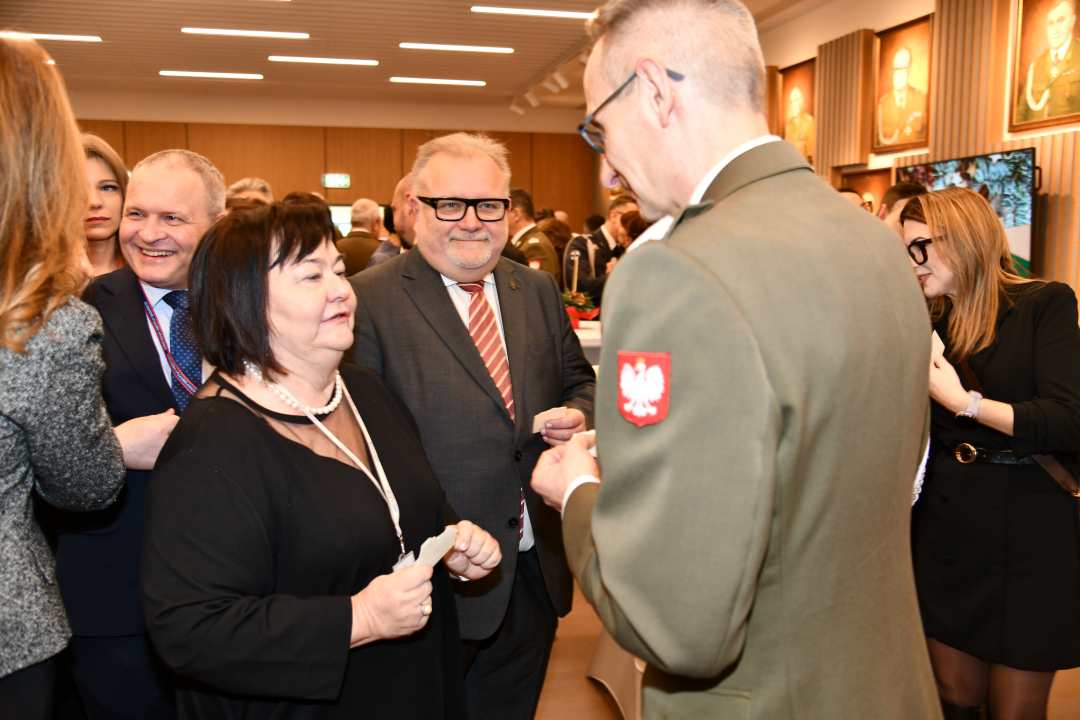 Dyrektor WIM dzieli się opłatkiem z pracownikami i gośćmi.