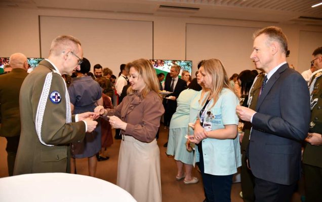 Dyrektor WIM dzieli się opłatkiem z pracownikami i gośćmi.