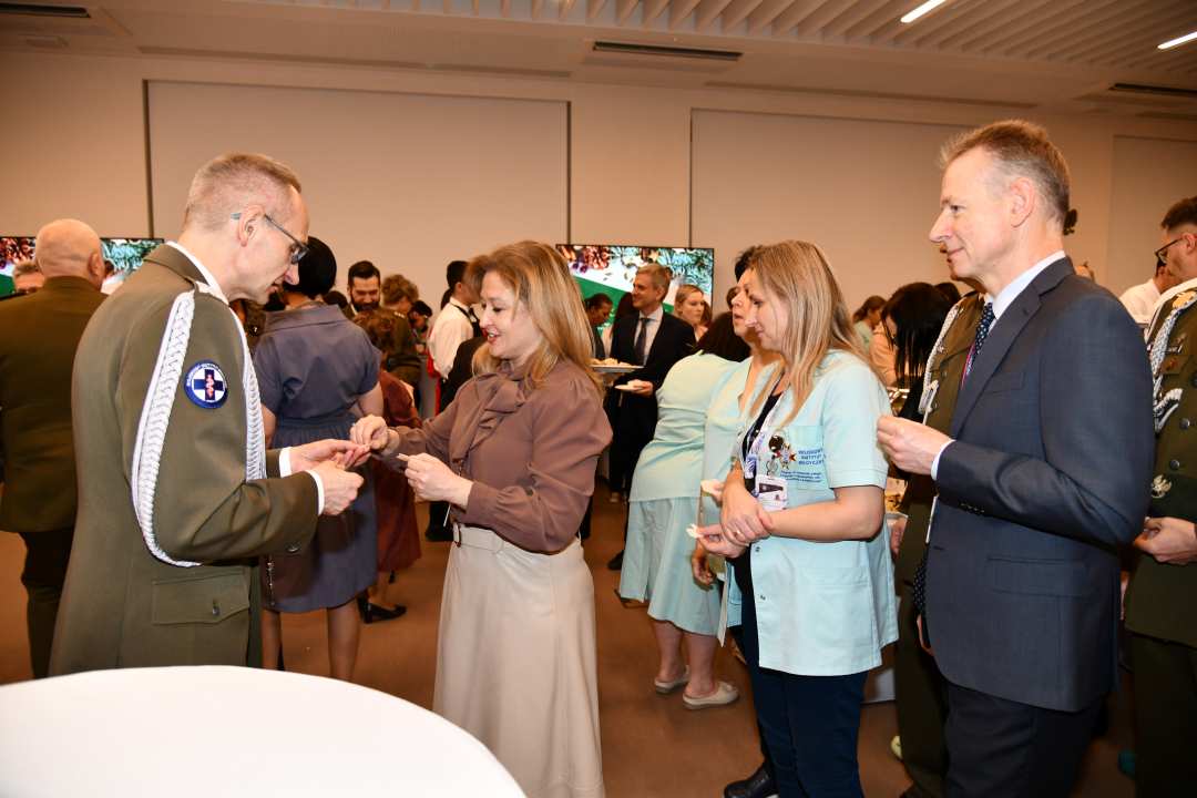 Dyrektor WIM dzieli się opłatkiem z pracownikami i gośćmi.