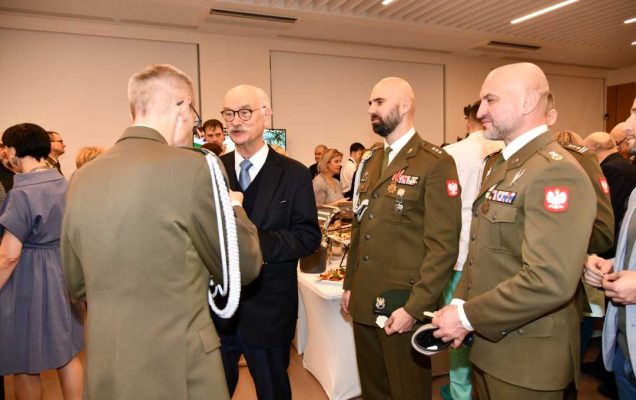 Dyrektor WIM dzieli się opłatkiem z pracownikami i gośćmi.