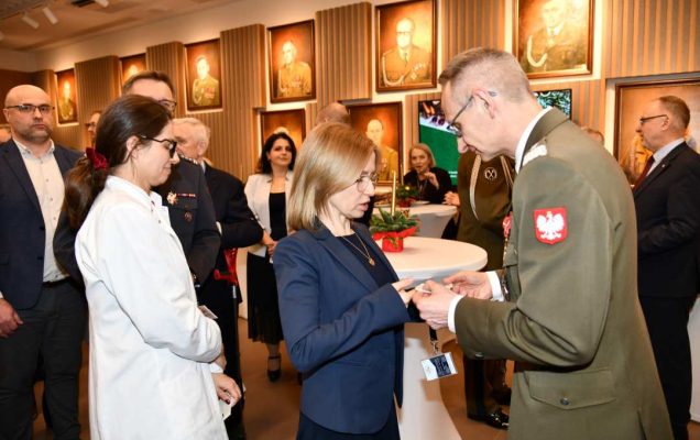 Dyrektor WIM dzieli się opłatkiem z pracownikami i gośćmi.
