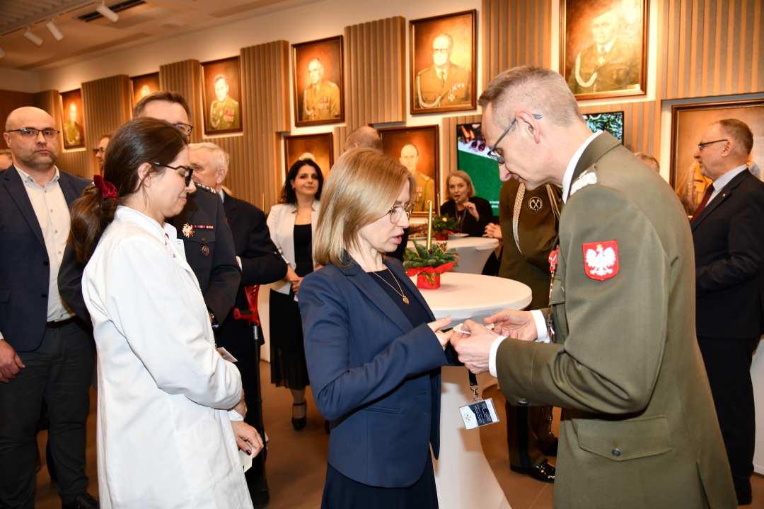 Dyrektor WIM dzieli się opłatkiem z pracownikami i gośćmi.