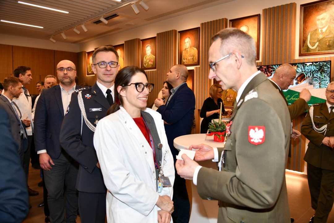 Dyrektor WIM dzieli się opłatkiem z pracownikami i gośćmi.