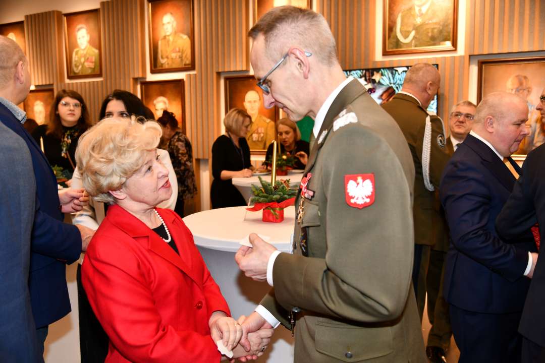 Dyrektor WIM dzieli się opłatkiem z pracownikami i gośćmi.