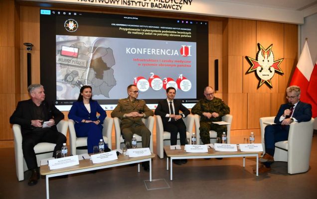 Paneliści siedzący w fotelach podczas debaty.