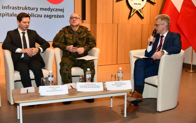 Paneliści siedzący w fotelach podczas debaty.