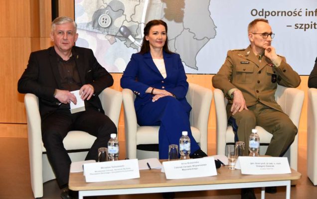 Paneliści siedzący w fotelach podczas debaty.
