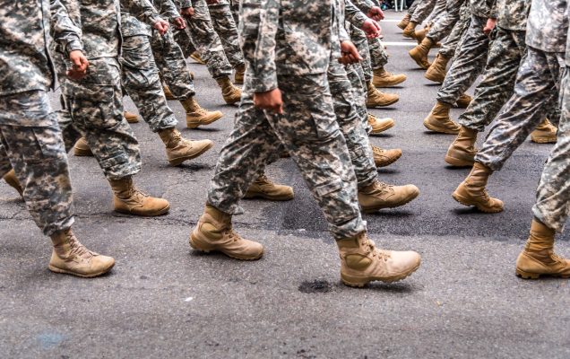 nogi żołnierzy maszerujących po drodze aswaltowej