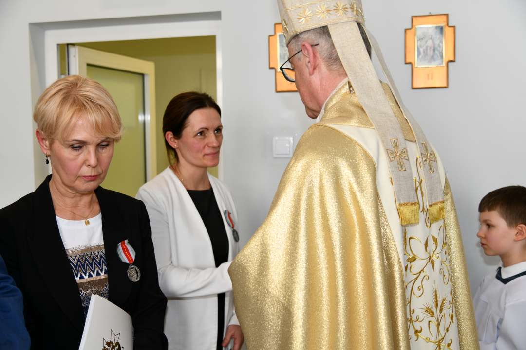 Biskup wręcz medal pracownicy WIM.