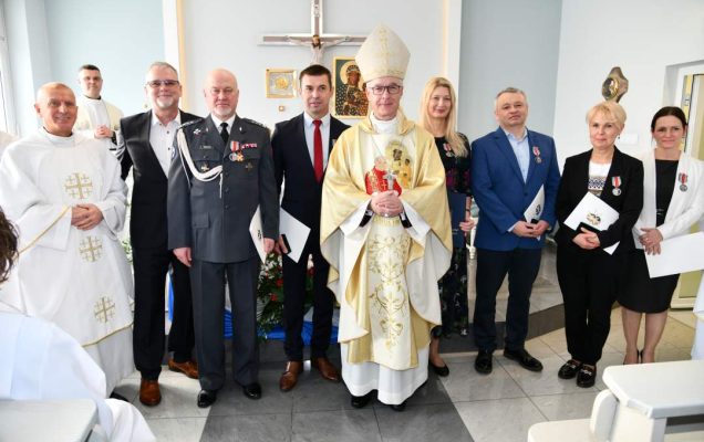 Zdjęcie grupowe oznaczonych medalem z biskupem.