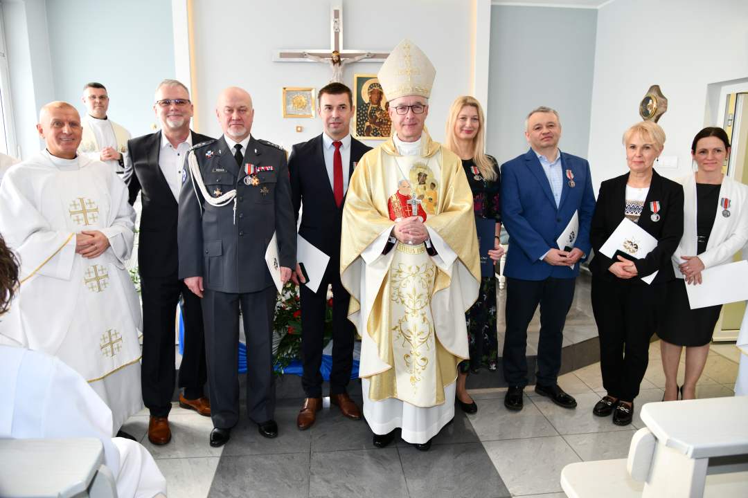 Zdjęcie grupowe oznaczonych medalem z biskupem.